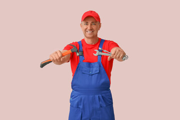 Canvas Print - Portrait of male mechanic with tools on pink background