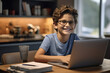 © Samira - Smiling boy in eyeglasses sitting at table with laptop in office