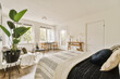 © ADDICTIVE STOCK - Modern bedroom with bed and houseplant against windows