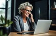 © NovaVision - Joyful Middle-Aged Businesswoman Engaging in a Phone Call at Her Office Desk. Generative ai