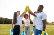 © Богдан Маліцький - group of multiracial people in gloves with garbage bags high-fiving and celebrating success together in the park