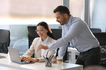 Poster - Colleagues working on laptop at desk in office