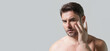 Banner of man with perfect skin touch face after shaving. Skin care healthcare cosmetic procedures concept. Close up man looking in mirror, sensitive skin, cosmetology treatment. Skin care.