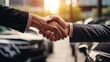 Businessman shaking hand with car dealer, blur car background 