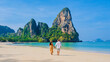 © Fokke Baarssen - Railay Beach Krabi Thailand, the tropical beach of Railay Krabi, a couple of men and women on the beach, with a view of idyllic Railay Beach in Thailand