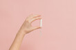 Hand holding medical feminine tampon. Cotton swab. Menstruation