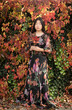 © Milou Dirks - asian girl floral dress hiding in autumn park holding leaves