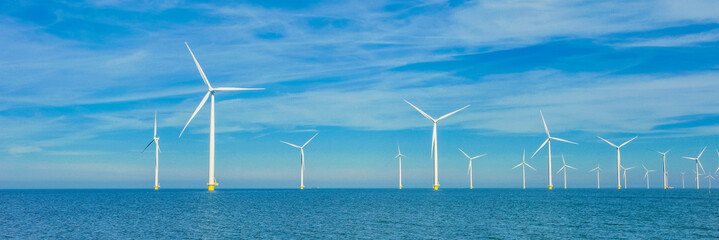 Drone view at windmill turbines, Windmill park with clouds and a blue sky, windmill park in the ocean aerial view with wind turbine Flevoland Netherlands