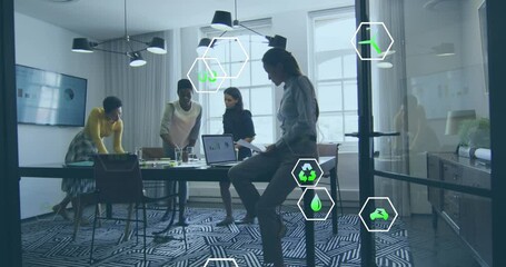 Poster - Animation of multiple icons over diverse female coworkers discussing reports on laptop in office