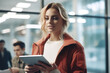 © vefimov - Woman Holding Tablet in Front of Group