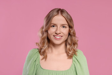 Wall Mural - Portrait of beautiful woman with blonde hair on pink background