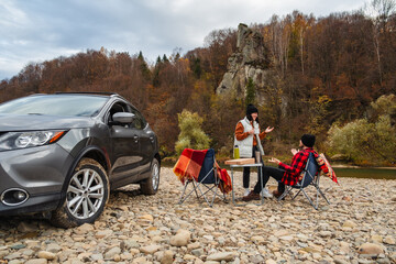 Poster - couple having picnic at autumn mountain river