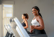© Chutipon - African woman  jogging in indoor fitness active young woman running on treadmill at the gym exercising. Run on a machine.