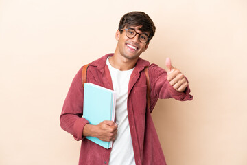 Young student caucasian man isolated on ocher background with thumbs up because something good has happened