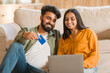 © Prostock-studio - Indian couple shopping online with laptop and credit card at home
