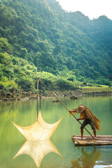 Wall Mural - view of fishermen fishing on river in Thung mountain in Tra Linh, Cao Bang province, Vietnam with lake, cloudy, nature