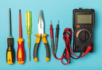 Wall Mural - Electrician tools on background. Multimeter,construction tape,electrical tape, screwdrivers,pliers,an automatic insulation stripper, socket and LED lamp. Flatley. electrician concept.