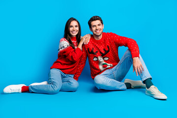 Poster - Full size photo of two nice looking cheerful couple sitting on floor making family picture on christmas isolated on blue color background