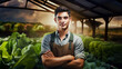 © Nikname - Young male agronomist standing in a greenhouse crossing his arms in front of him.