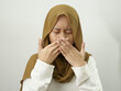 Asian female muslim woman covering her mouth due to bad breath, halitosis