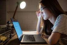 A Young Woman Works On Her Laptop At Home. It Is Characterized With Headaches That Occur When Stressed.