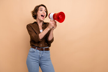 Poster - Photo of shiny excited girl dressed brown shirt screaming bullhorn empty space isolated beige color background