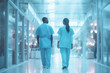 © SnapVault - Two medical professionals in surgical scrubs walking down a lighted hospital corridor, symbolizing dedication and commitment to healthcare.