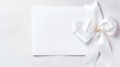 © Erik - Blank white sheet of paper with a silk ribbon gift bow. Generative AI,