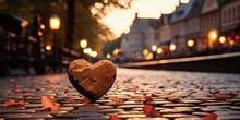A Piece Of Stone Carved In The Shape Of A Heart Lying On A Cobblestone Road In A Tourist Town.