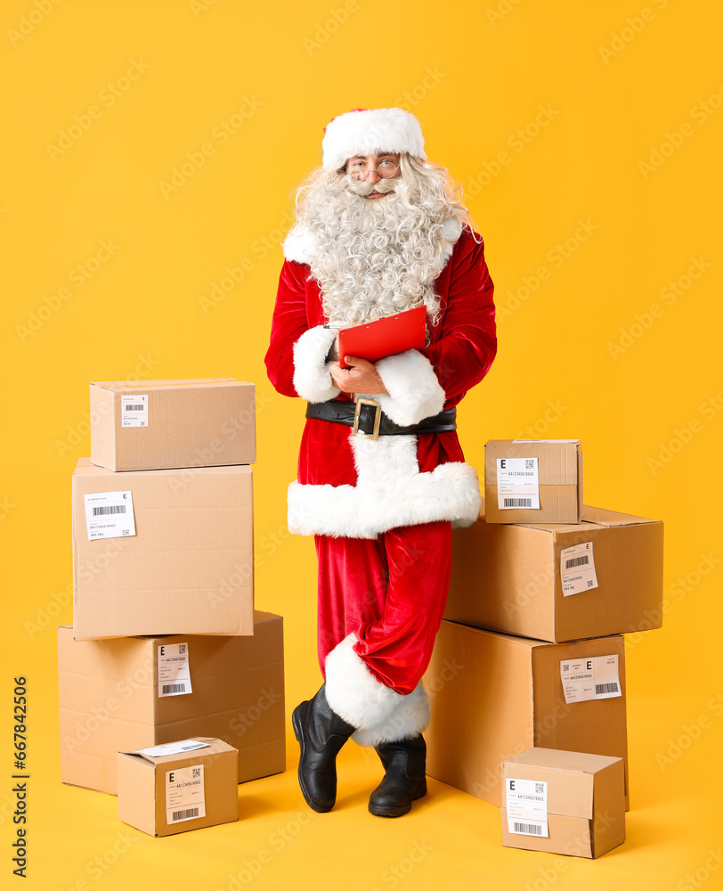 Santa Claus with clipboard checking list of parcels on yellow background