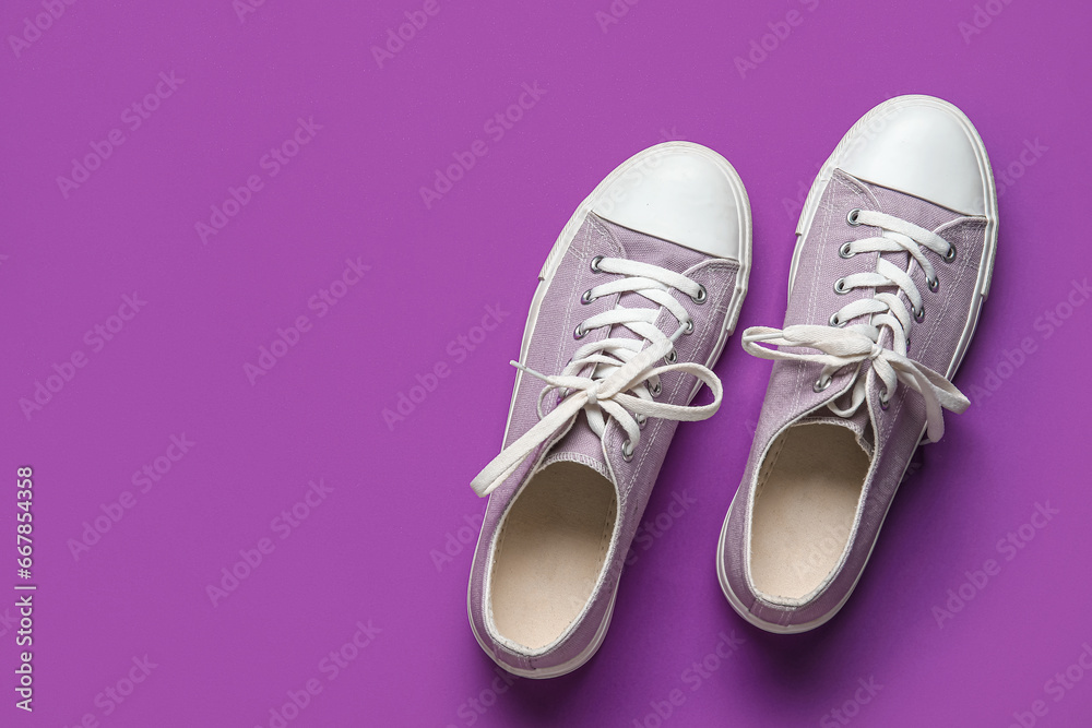 Stylish sneakers on purple background