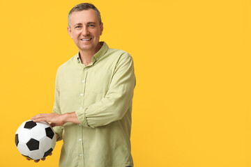 Canvas Print - Handsome mature man with soccer ball on yellow background