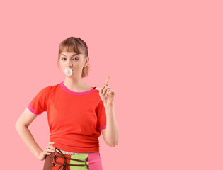 Canvas Print - Beautiful young woman with chewing gum pointing at something on pink background