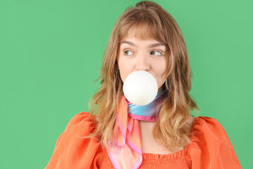 Sticker - Beautiful young woman with chewing gum on green background, closeup