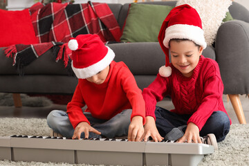 Sticker - Cute little boys playing synthesizer at home on Christmas eve