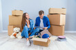 © gorynvd - Young couple taking selfies in their new home while sitting among cardboard boxes. Happy attractive young couple is moving, making a selfie, cuddling and smiling.