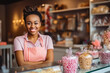 Young black female candy shop owner standing behind counter, young beautiful woman selling candy and sweets at the candy store