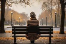 In The Midst Of Nature's Embrace, A Woman Sits On A Park Bench, Her Silhouette Painting A Poignant Picture Of Female Despondency And Quiet Contemplation