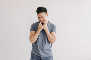 Wall Mural - Shy and embarrassment funny asian man in blue t-shirt isolated on white wall.