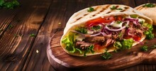 Panorama Banner With Spicy Turkish Doner Kebab Filled With Flaked Spit Roasted Meat And Fresh Salad In A Toasted Tortilla Wrap Served On Brown Paper On Rustic Wood With Copy Space