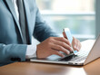© Akilmazumder - Business person using laptop and man or woman operating laptop and making a note, Business Office photo, Business Working environment, AI-generated business Photo