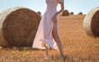 Beautiful legs of a girl dress in a field with hay