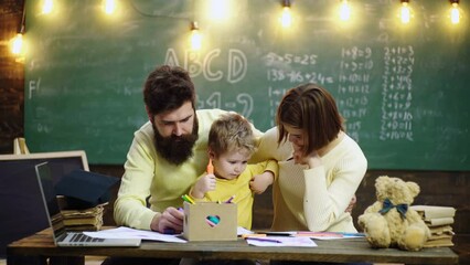 Fototapete - Schoolboy and parents studying. Parents teaching children. Family in early development concept. Father mother and child son painting together at home.