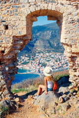 Wall Mural - Woman tourist looking at panoramic view of Monemvasia town- Travel in Greece- Europa