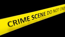 A Yellow Crime Scene Tape With The Words CRIME SCENE DO NOT CROSS Written On It In Front Of Police Red And Blue Flasher Siren Effect And Different Depth Of Field. Shallow Depth Of Field.