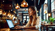 © anmitsu - A beautiful girl using a computer in a cafe,