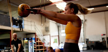 Woman Swinging A Kettlebell At The Gym