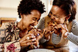 © Flamingo Images - Laughing women eating croissants