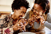 Laughing women eating croissants