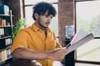 © deagreez - Photo portrait of attractive young man wear yellow shirt boss read employee report modern workplace room home design